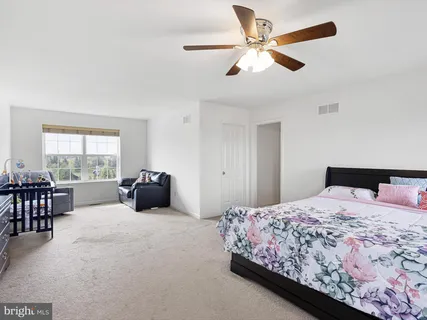 a bedroom with a large bed and a chandelier
