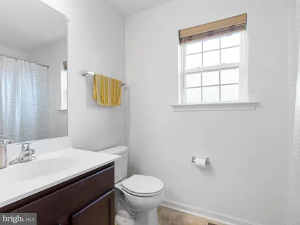 a bathroom with a sink a toilet and a window