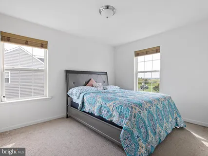 a bed sitting in a bedroom next to a window