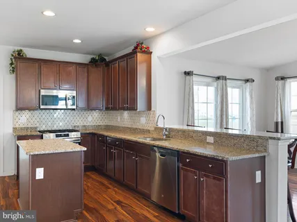 a kitchen with stainless steel appliances granite countertop wooden cabinets a sink and dishwasher