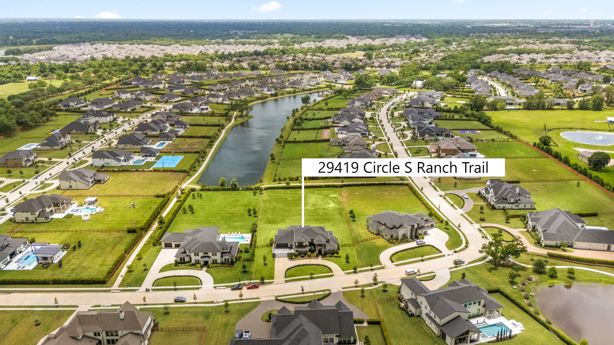 29419 Cir S Rnch Trail Fulshear, TX 77406 - Photo 34 of 45 This elevated aerial view beautifully frames the estate, showcasing its seamless transition to the quiet neighborhood lake positioned directly at the back.