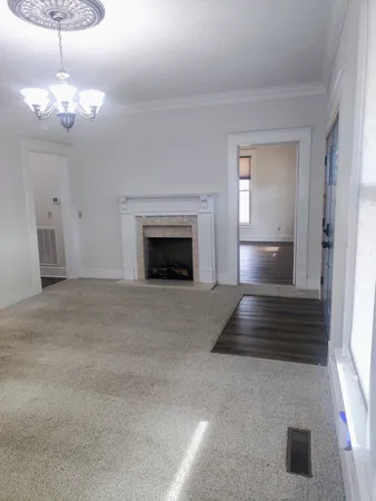 a view of empty room with chandelier fan