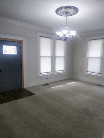 a view of a livingroom with a chandelier furniture and windows