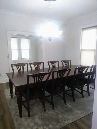 a view of an empty room with wooden floor fire place and a window