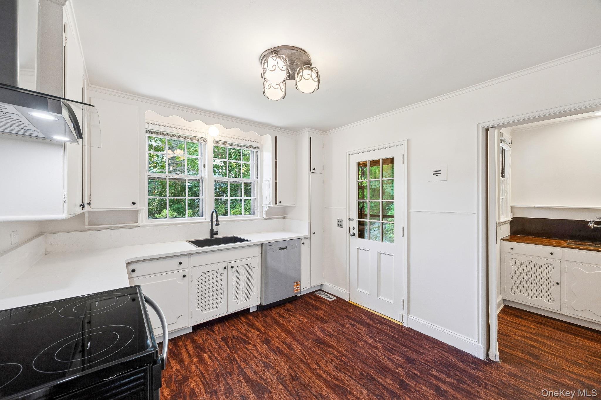 6 Fox Meadow Road Scarsdale, NY 10583 - Photo 5 of 20 Kitchen featuring wall chimney exhaust hood, dark wood-style flooring, white cabinetry, crown molding, and stainless steel dishwasher