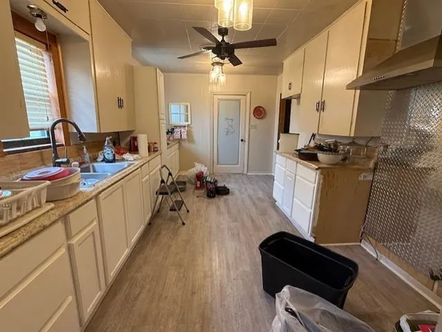 a kitchen with a sink appliances wooden floor and a counter top space