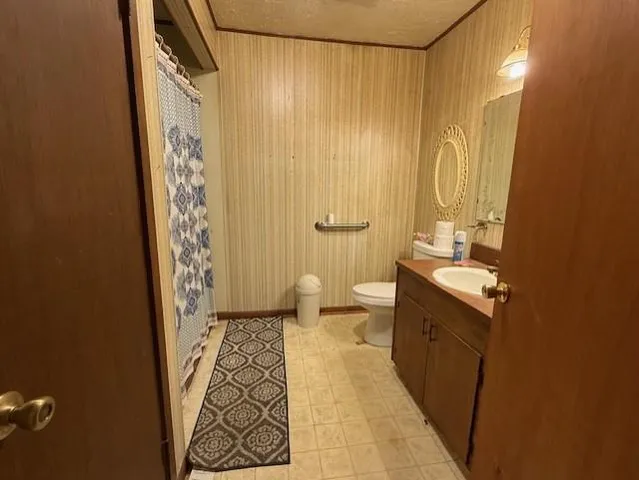 a bathroom with a sink and mirror with toilet