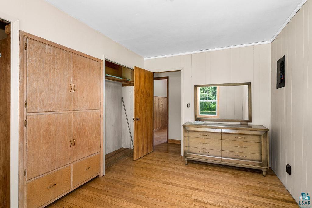 2592 Strandberg Road Barnum, MN 55707 - Photo 5 of 44 Hardwood flooring throughout featuring built-in cabinetry, a window with natural light, and paneled walls