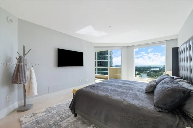 a spacious bedroom with a bed and a flat screen tv