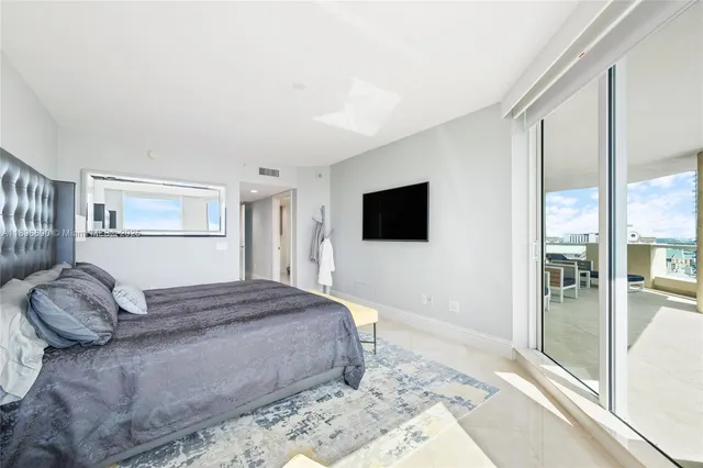 a bedroom with a bed and a flat screen tv