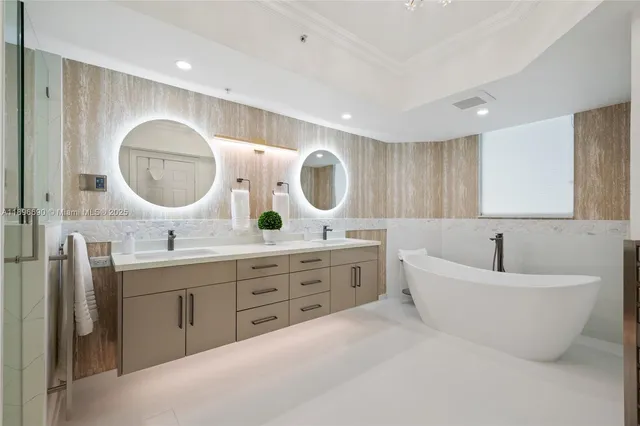 a spacious bathroom with a double vanity sink mirror and bathtub