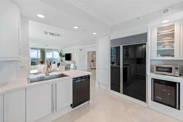 a kitchen with stainless steel appliances kitchen island granite countertop a refrigerator and a sink