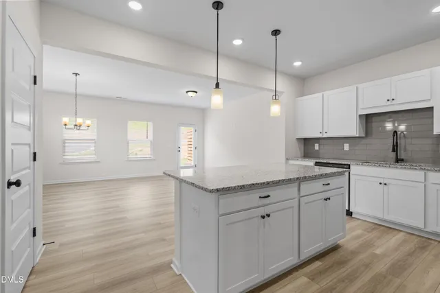 a kitchen with white cabinets and window