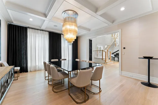 a view of a dining room with furniture a chandelier and wooden floor