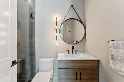 a bathroom with a sink a toilet and a mirror