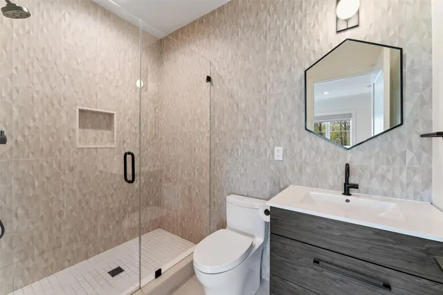 a bathroom with a sink a toilet and shower