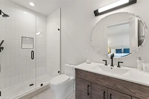 a bathroom with a sink a toilet and shower