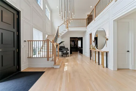a view of a hallway with wooden floor windows and a kitchen view