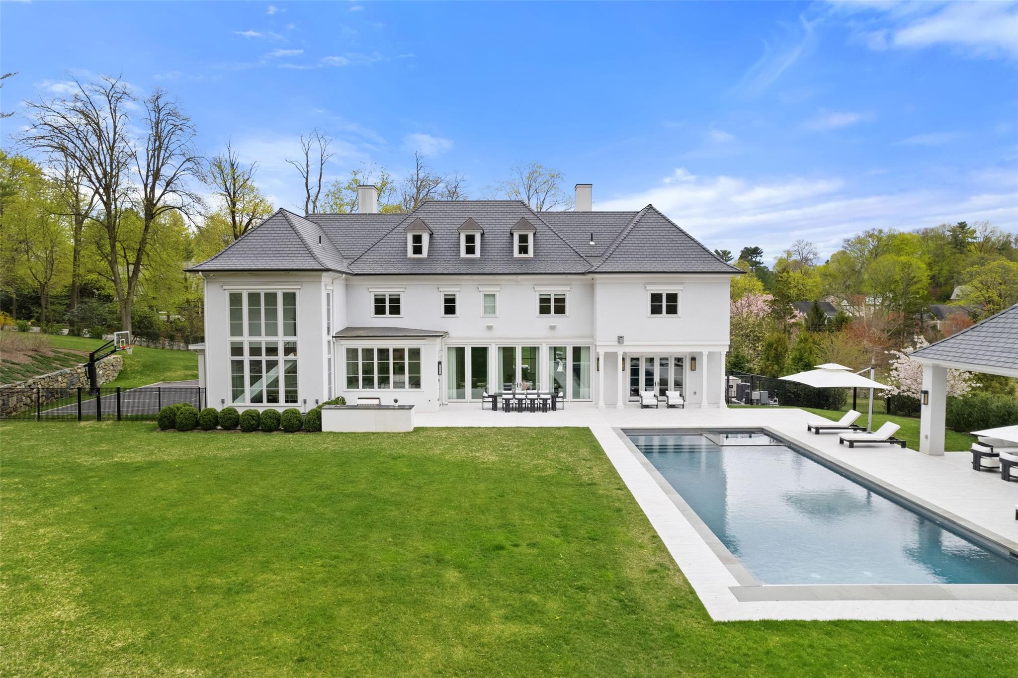 17 Oxford Road Scarsdale, NY 10583 - Photo 36 of 49 a view of a house with a swimming pool and a chairs