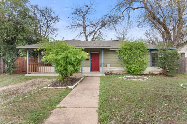 a front view of a house with a yard and trees