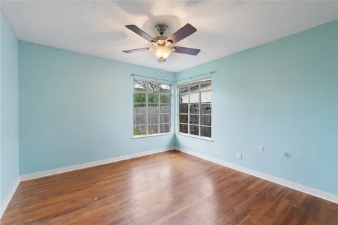 a view of wooden floor and a chandelier fan in a room