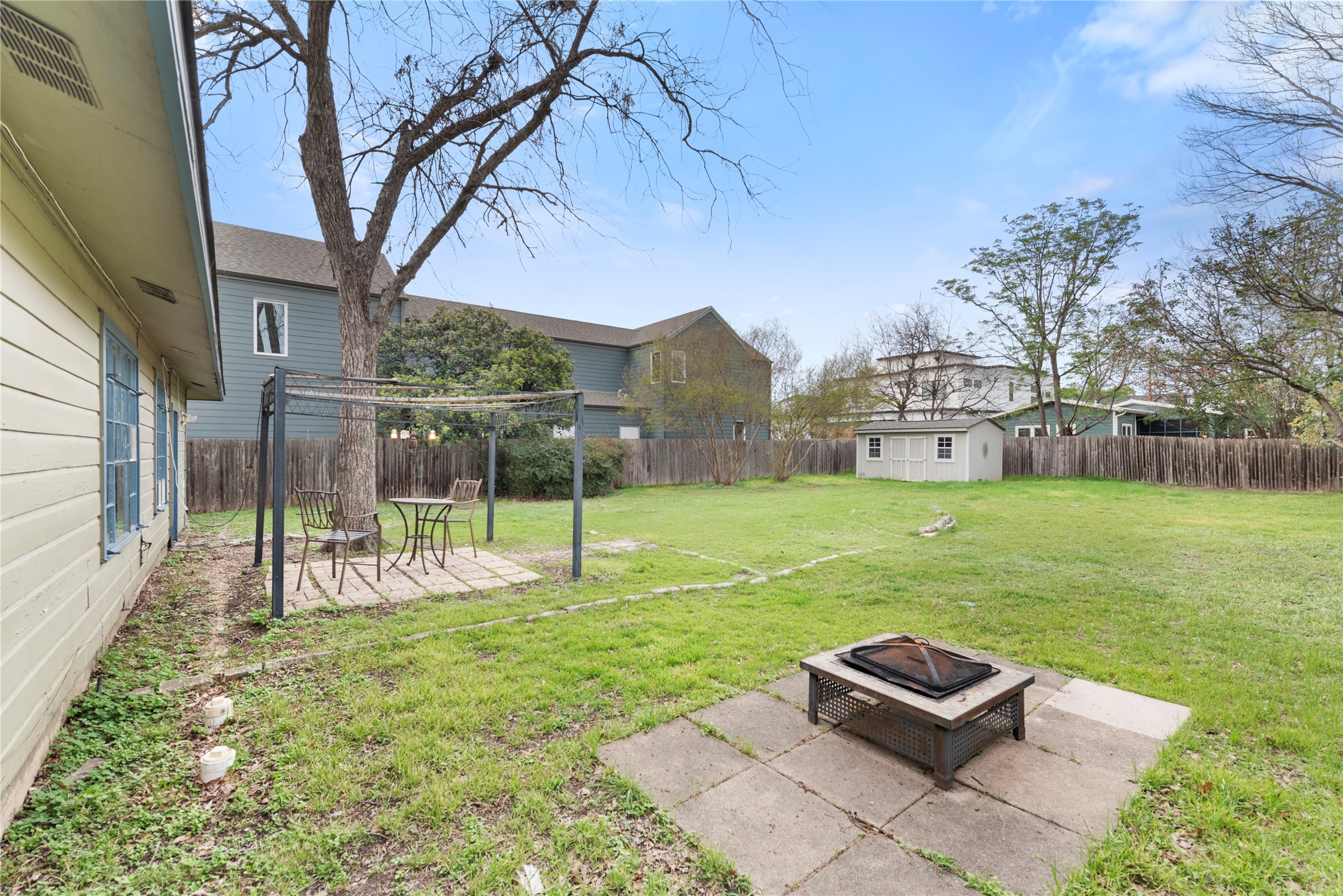 1900 Justin Lane Austin, TX 78757 - Photo 23 of 27 Fenced backyard with an outdoor fire pit, a patio area, and a shed