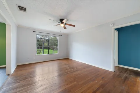 a view of room with hardwood floor and ceiling fan