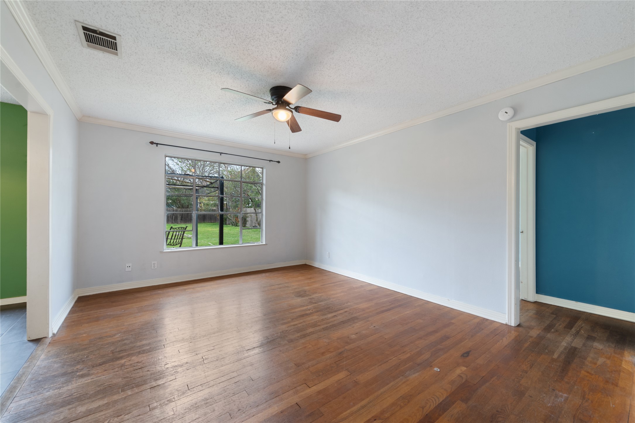 1900 Justin Lane Austin, TX 78757 - Photo 5 of 27 Spare room with dark wood-style floors, crown molding, a textured ceiling, and a ceiling fan