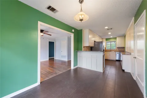 a view of a living room and kitchen with furniture wooden floor and windows
