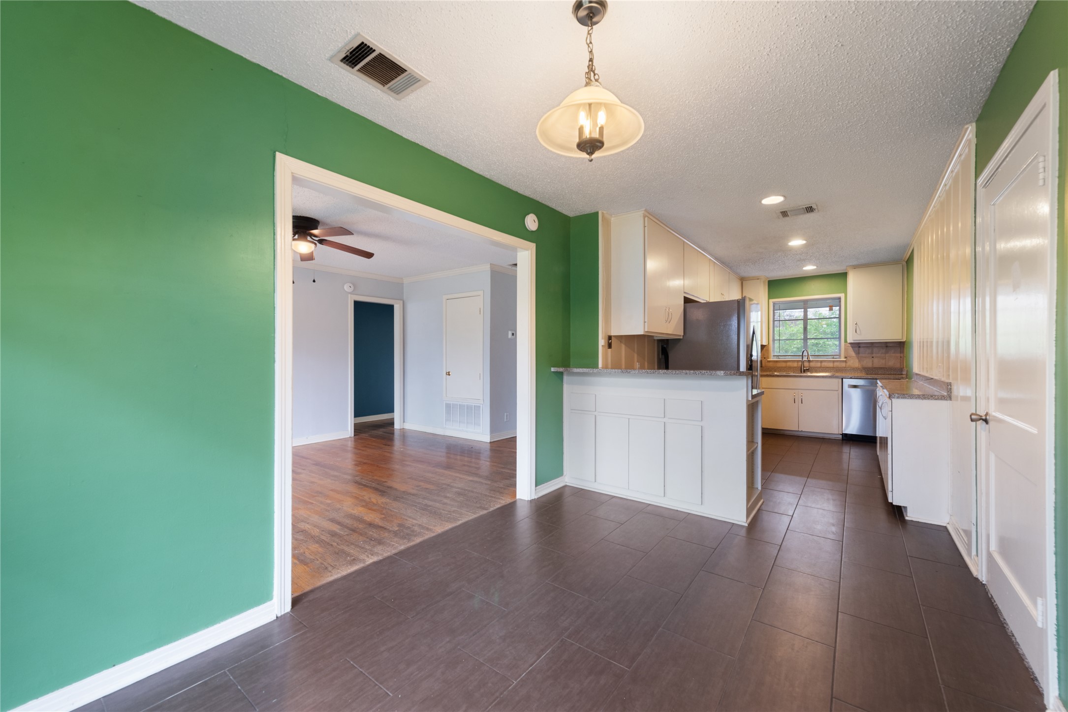 1900 Justin Lane Austin, TX 78757 - Photo 7 of 27 Kitchen featuring light countertops, a textured ceiling, a peninsula, hanging light fixtures, and a ceiling fan