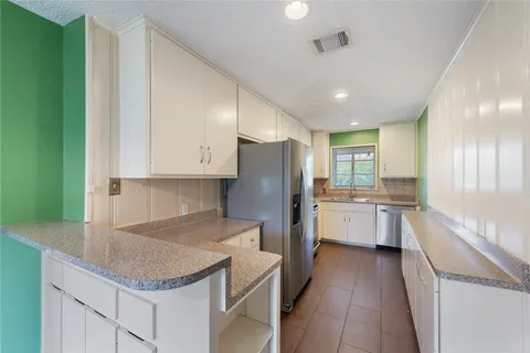 a kitchen with a refrigerator sink and cabinets