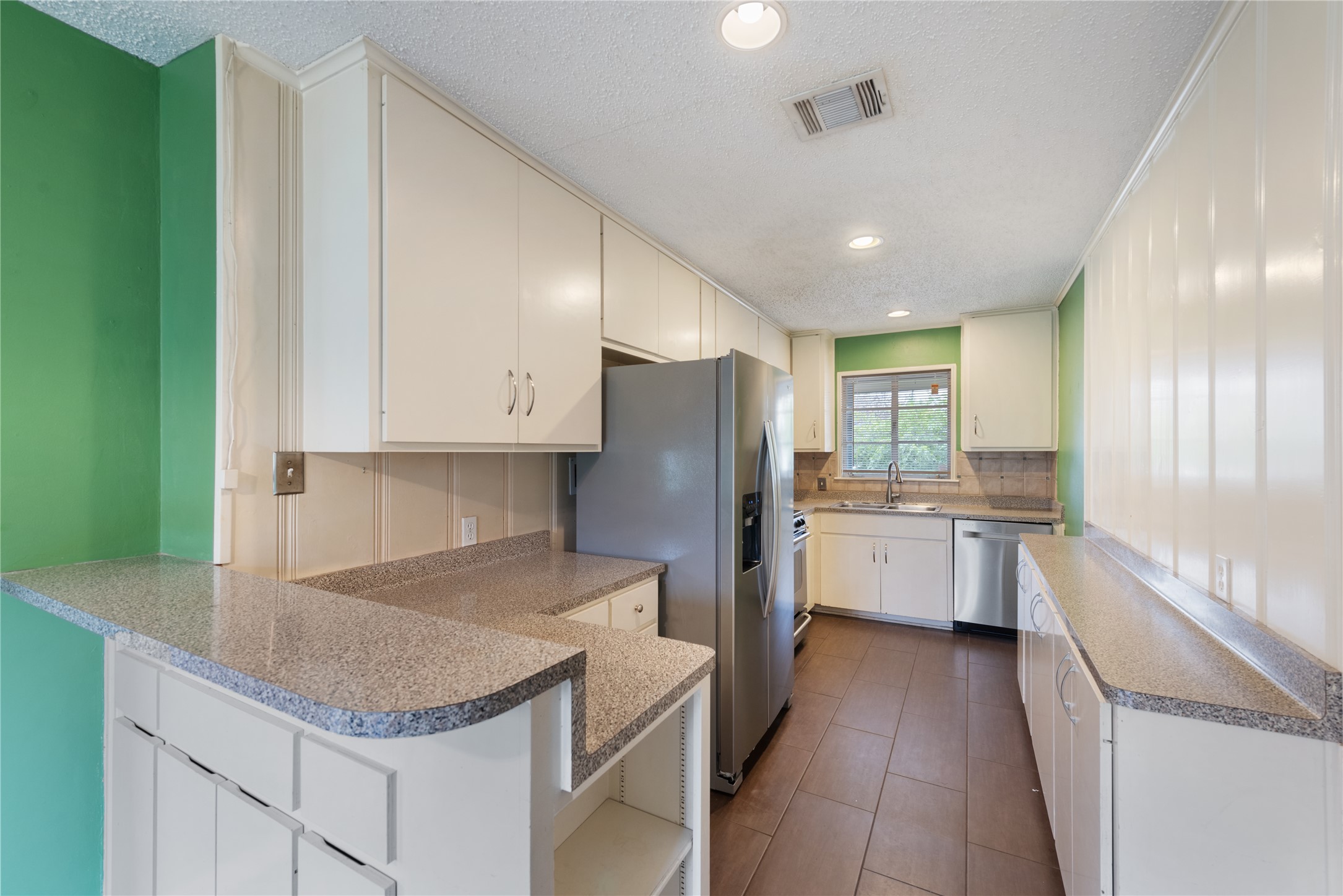 1900 Justin Lane Austin, TX 78757 - Photo 8 of 27 Kitchen featuring stainless steel appliances, recessed lighting, white cabinetry, a peninsula, and a textured ceiling