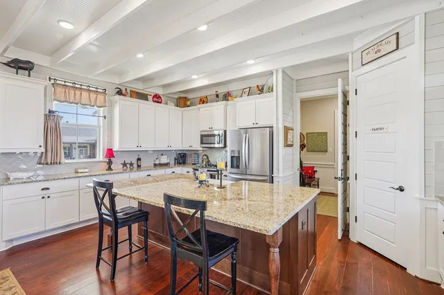 a kitchen with stainless steel appliances kitchen island granite countertop a refrigerator and microwave