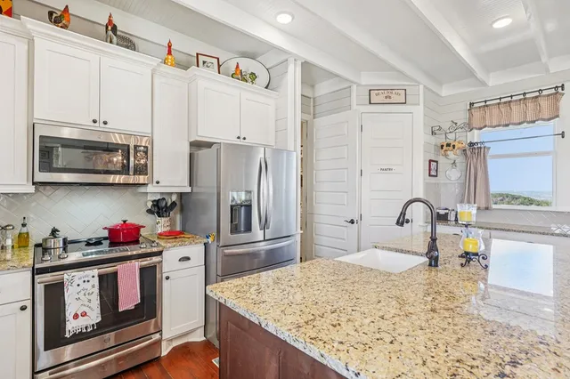 a kitchen with sink stove and cabinets