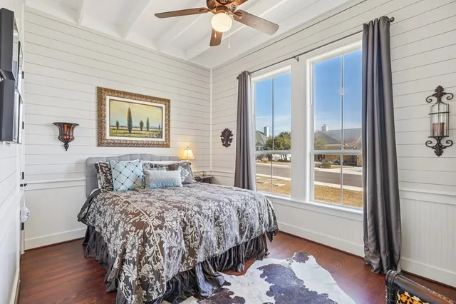 a bedroom with a bed dresser and a large window