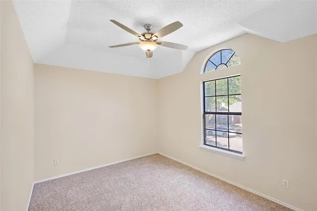 an empty room with windows and fan