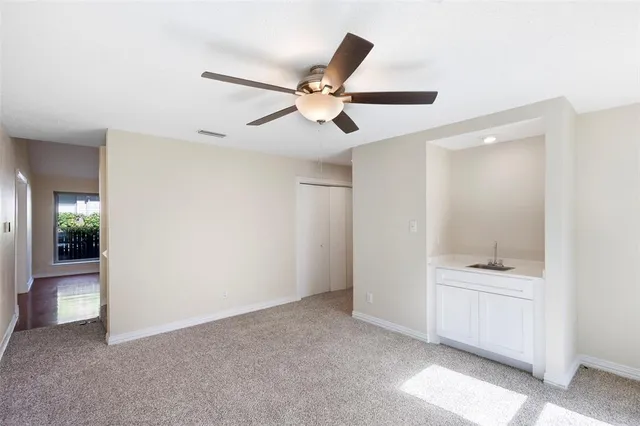 a view of an empty room and kitchen