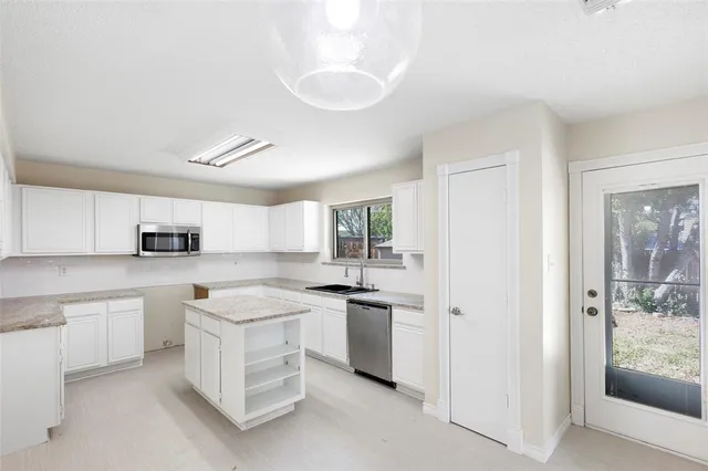 a kitchen with white cabinets and white appliances