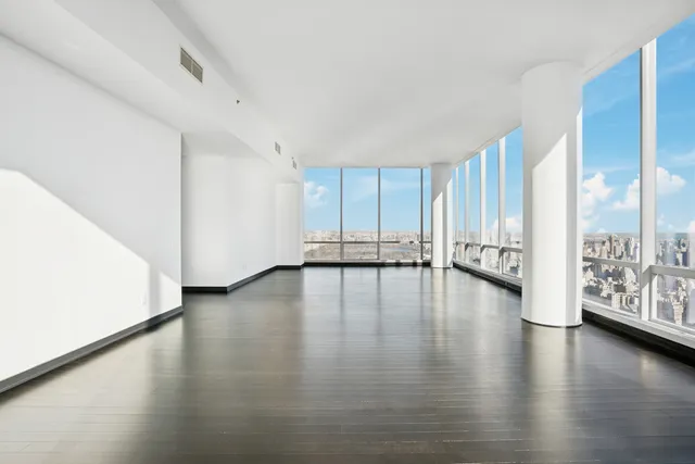 a view of empty room with wooden floor and windows
