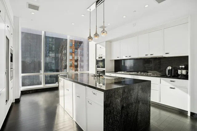 a kitchen with stainless steel appliances granite countertop a sink a stove and cabinets
