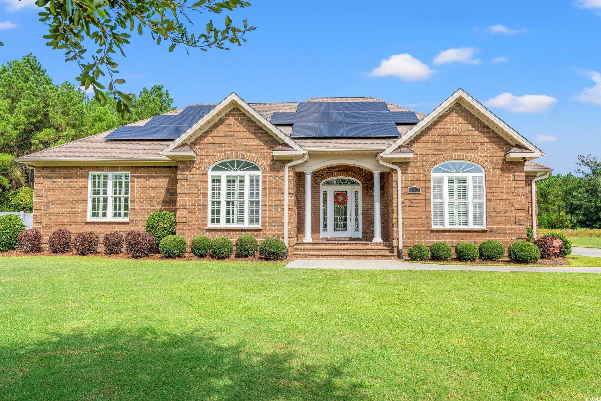 Ranch-style house with brick siding, roof with shingles, and roof mounted solar panels