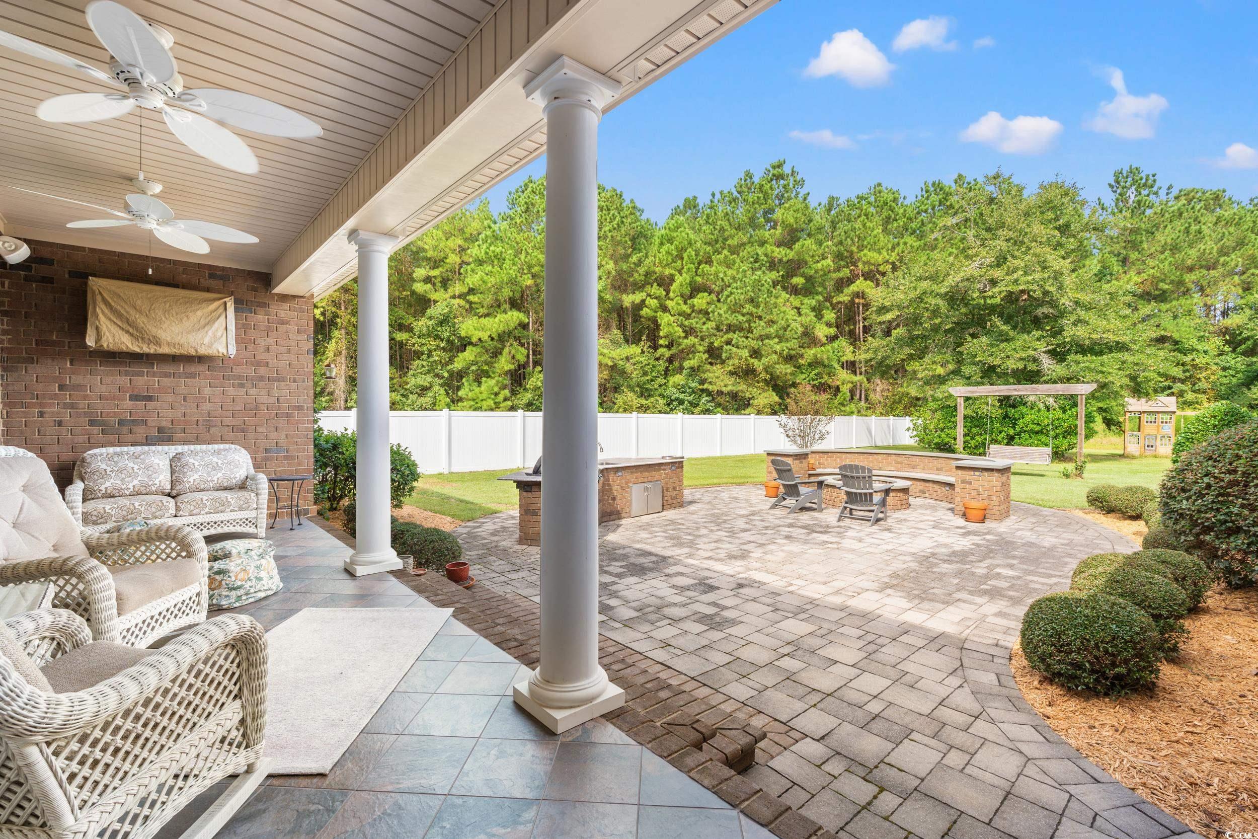 3609 Long Ave Extension Conway, SC 29526 - Photo 28 of 40 Fenced backyard featuring a patio area, ceiling fan, an outdoor living space with a fire pit, and view of scattered trees