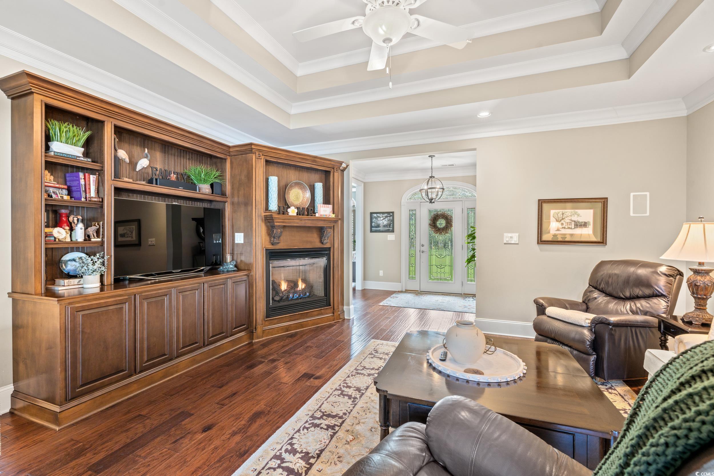 3609 Long Ave Extension Conway, SC 29526 - Photo 6 of 40 Living room with a tray ceiling, ornamental molding, dark wood-style flooring, a glass covered fireplace, and french doors