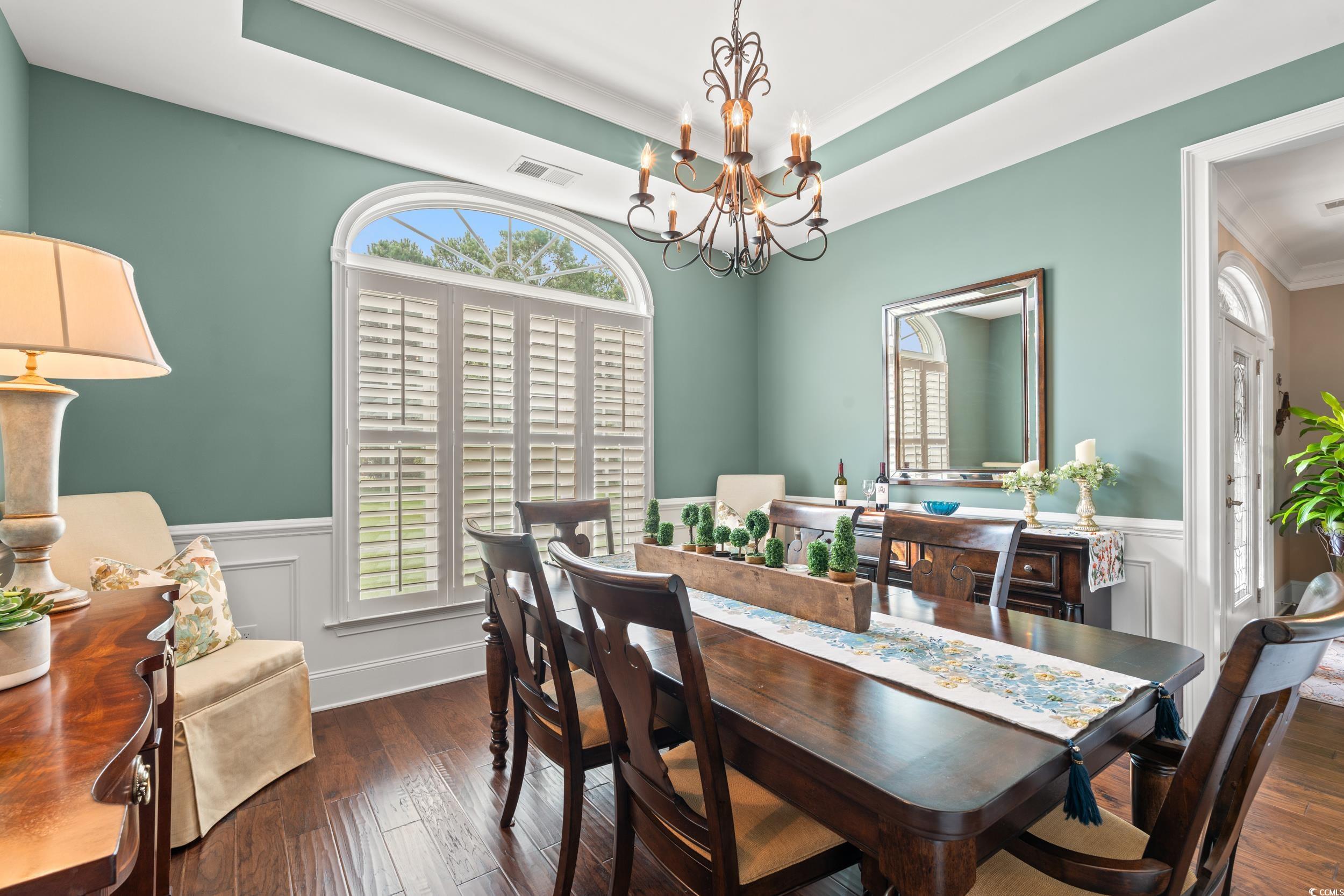 3609 Long Ave Extension Conway, SC 29526 - Photo 7 of 40 Dining space featuring a tray ceiling, plenty of natural light, wainscoting, dark wood finished floors, and a chandelier