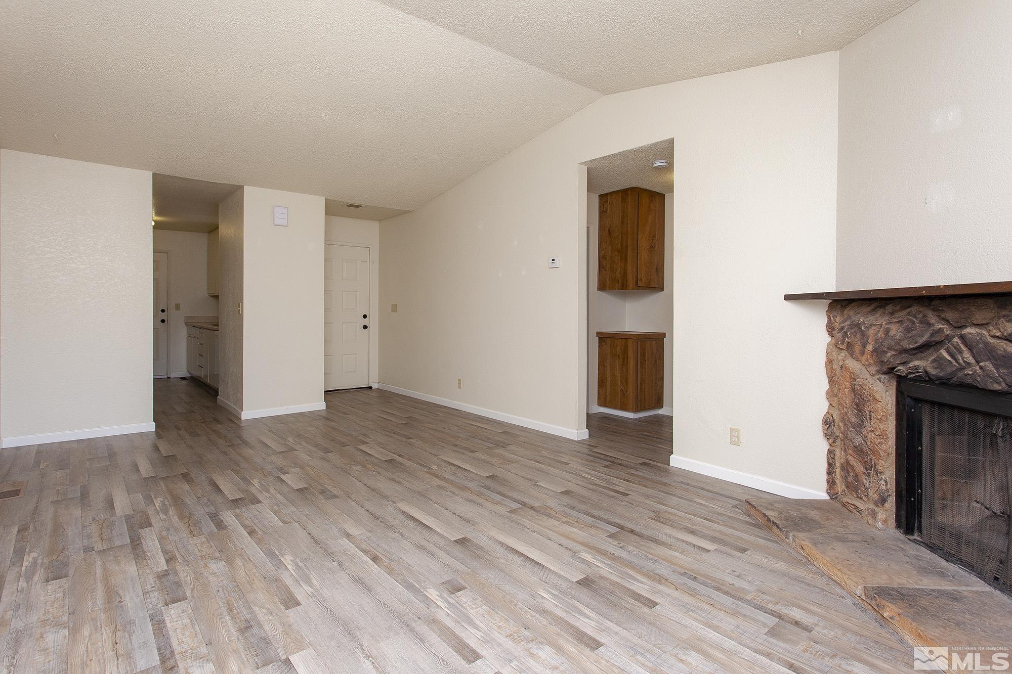 10046 Humite Lane Reno, NV 89506 - Photo 3 of 17 a view of empty room with wooden floor and fireplace