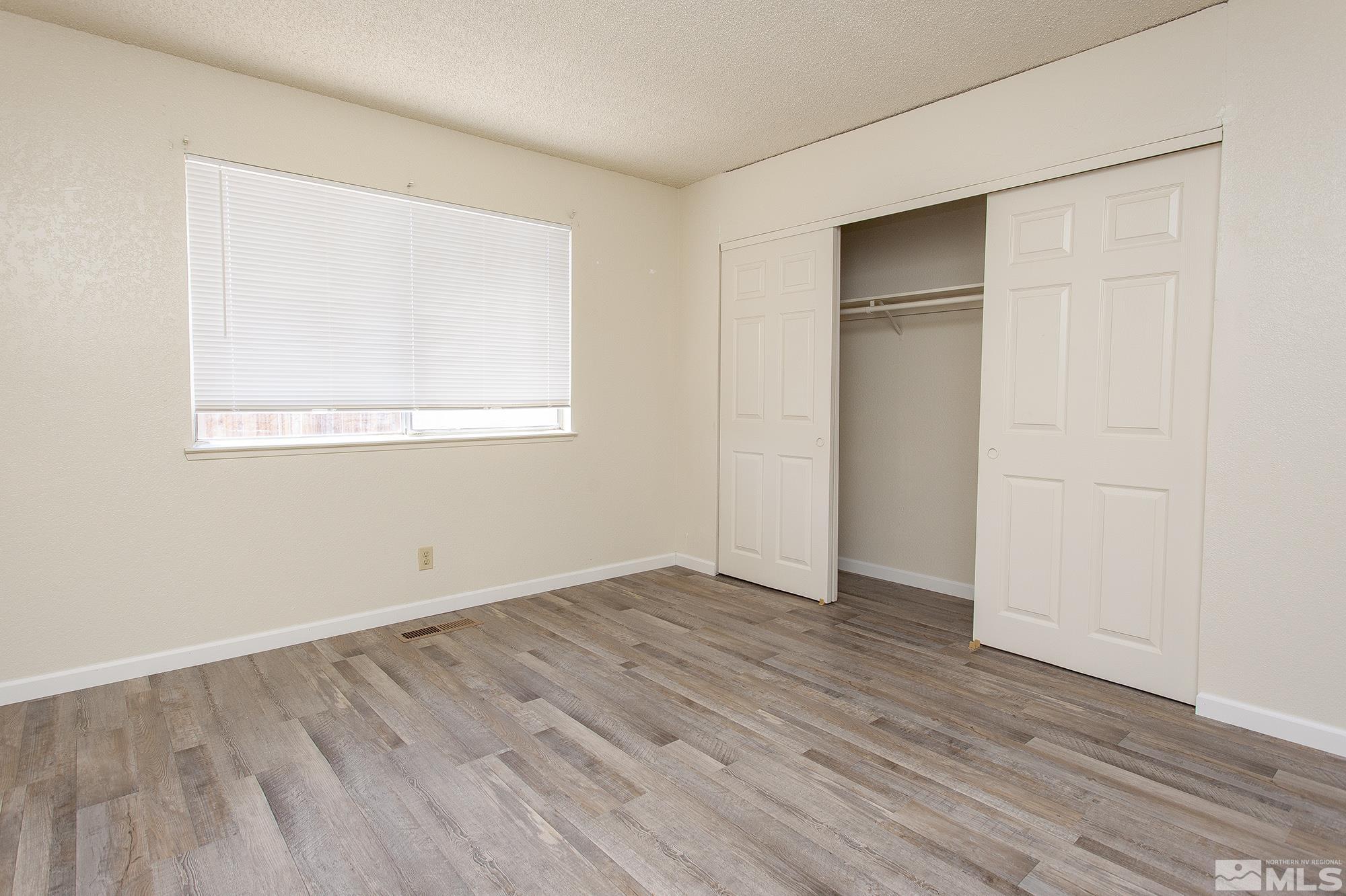 10046 Humite Lane Reno, NV 89506 - Photo 10 of 17 an empty room with wooden floor and windows