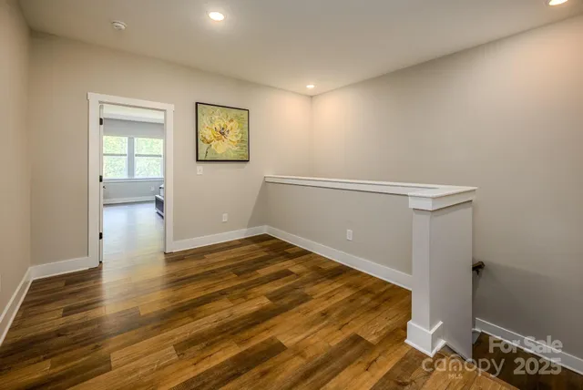 a view of empty room with wooden floor