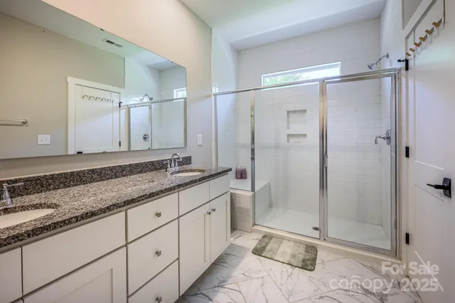 a bathroom with a shower sink and mirror