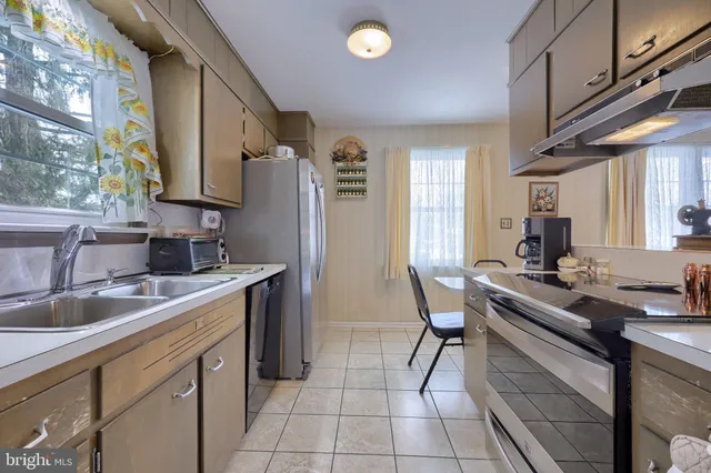 a kitchen with stainless steel appliances a sink stove and cabinets