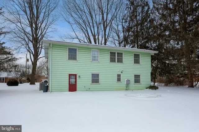 a view of a house with a yard covered in snow